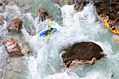 Male kayaker crossing whirlpool in green colored Soca river near Bovec, Slovenia