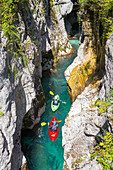 Kayakers on Soca river originating in Trigval mountains. The river is famous for all kinds of white water activities, Triglav National Park, Slovenia