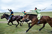 The horse races are by age five years with the riders no older than 13 years of age when they retire. Many of the riders wear vibrantly colored satin capes and matching suits to be recognized from a far distance. Most go bareback, though a few ride on light racing saddles. Many only wear socks to cut down on the weight of bulky boots and almost all have a dashur a crop to urge their horses on. They compete for 20 kilometers bareback horse race. Annual Naadam Festival in Bunkhan, Mongolia.