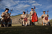 Local Mongol Band plays Mongolia's National instrument, the Morin khuur (horse-head fiddle) at Lapis camp in Bunkhan valley, Arkhangai Province, Mongolia. Mongols sing to their animals, there are lullabies to coax sheep to suckle their lambs songs to order a horse forward, make it stop or come closer and croons to control a goat, to milk a cow, or imitate a camels cry.