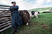 A Mongol nomad boy at his yak stable. Yak in Mongolia is milked twice a day, Bulgan, Central Mongolia, Mongolia