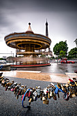 Karussell vor dem Eiffelturm bei regnerischen Wetter, im Vordergrund Liebesschlösser, Paris, Frankreich