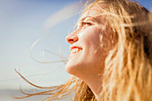 Close up carefree, smiling woman enjoying sunshine