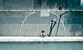 View from above young man meditating on urban sidewalk