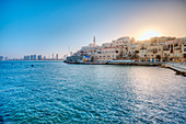 Sun rising over waterfront town, Israel