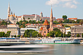 Blick auf die Fischerbastei und Matthiaskirche mit vorbeifahrendem Schiff im Vordergrund. Budapest, Ungarn