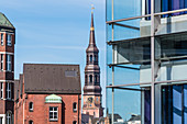 Turm der Katharinenkirche, eingerahmt von Häusern der Speicherstadt und moderner Bürofassade, Altstadt, Hamburg