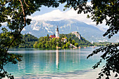 Winzige Insel mit einer Kirche, einer Burg auf einem Felsen und Bergblick, Bleder See, Slowenien, Europa