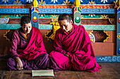 Asian monks reading on temple floor, Bhutan, Kingdom of Bhutan