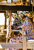 Asian girl weaving fabric, Myanmar