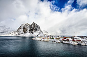 Verschneite Berge mit Blick auf die felsige Küste, Reine, Lofoten Inseln, Norwegen