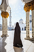 Frau beim Spaziergang an der Scheich-Zayid-Moschee, Abu Dhabi, Vereinigte Arabische Emirate
