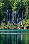 Waterfall pouring over rock formations to remote lake, Croatia