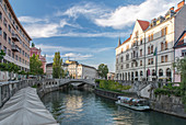 Buildings and pedestrian bridge over urban canal, Ljubljana, Central Slovenia, Slovenia