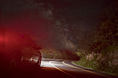 Car on winding road under starry sky, Front Royal, Virginia, USA