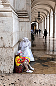 Trauriger Clown und Mime in Ecke sitzend, Arco da Rua Augusta, Lissabon, Portugal