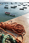 Im Vordergrund Seile, im Hintergrund Fischerboote im Fischerhafen von Cascais, Portugal