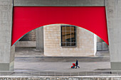 Mann mit Kinderwagen unter einer Brücke in Bilbao, Spanien