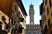 Durch eine Straßenschlucht gesehen der Turm des Palazzo Vecchio am Piazza della Signoria, Florenz, Toscana, Italien