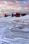 Neuschnee umgibt typische Fischerhäuser (Rorbu) im Winter, Ei, Lofoten, Arktis, Norwegen, Europa