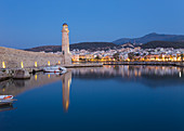 Blick über den venezianischen Hafen in der Abenddämmerung, Leuchtturm aus dem 16. Jahrhundert, reflektiert im Wasser, Rethymno (Rethymnon), Kreta, griechische Inseln, Griechenland, Europa