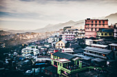 High angle view across a sprawling mountainside village under a cloudy sky.