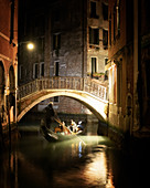 Gondel unter Brücke bei Nacht in Venedig, Italien, Europa