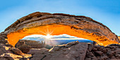 The sun rising under Mesa Arch, Canyonlands National Park, Moab, Utah, United States of America, North America