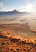 Luftaufnahme vom Heißluftballon im Morgengrauen über herrliche Wüstenlandschaft von Sanddünen, Bergen und Feenkreisen, Namib Rand Wildreservat Namib Naukluft Park, Namibia, Afrika