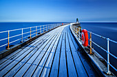 Frost sits on the timbers of Whitby Pier as it extends out to the sea on a cold winters morning, Whitby, North Yorkshire, Yorkshire, England, United Kingdom, Europe