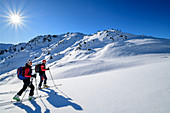 Man and woman on ski tour ascend to Regenfeldjoch, Regenfeldjoch, Kitzbüheler Alpen, Tyrol, Austria