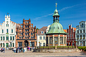 Marktplatz (market place square) in the centrum of Wismar, Brick Gothic Bürgerhaus (patrician's home) called the Alter Schwede (The Old Swede), erected around 1380. "Wasserkunst", historic ornate structure on the site of a 16th-century water fountain designed by Philipp Brandin. Wismar stadt, Mecklenburg–Vorpommern, Germany.