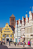 Krämerstraße, view from south toward north, at the end of the street yellow building of Löwenapotheke, tower of St. Nikolai church, Wismar stadt, Mecklenburg–Vorpommern, Germany.