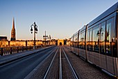 France, Gironde, Bordeaux, area listed as World Heritage by UNESCO, Pont de Pierre on the Garonne River, in the background Saint Michel church and the gate of Bourgogne