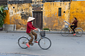 Cyclists on a street in Hoi An, Vietnam.