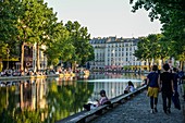 Frankreich, Paris, Canal Saint-Martin, Spaziergänger auf einem asphaltierten Weg
