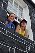 Zwei Urlauberinnen schauen aus dem Fenster ihrer Unterkunft, Plockton, Highlands