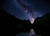 Toblacher See at night with Milky Way in the Dolomites, reflection in the mountain lake, South Tyrol