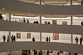 VISITOR ON THE SPIRAL STAIRCASE IN THE GUGGENHEIM MUSEUM OF NEW YORK, THE UPPER EAST SIDE, MANHATTAN, NEW YORK CITY, NEW YORK, UNITED STATES, USA