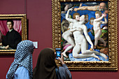 VEILED WOMAN TAKING A PHOTO OF THE PAINTING BY BRONZINO, AN ALLEGORY WITH VENUS AND CUPID, INSIDE THE NATIONAL GALLERY, LONDON, GREAT BRITAIN, EUROPE