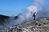 Man comes out of the volcanic steam at the crater rim on the volcano, Vulkano Island, Aeolian Islands, southern Italy