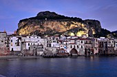 Abends am Strand von Cefalu mit seinen alten Uferhäusern unter dem Felsen, Nordküste, Sizilien, Italien