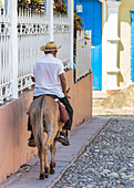 Cuban rides his donkey through Trinidad, Cuba
