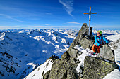Frau auf Skitour steigt über Felsgrat zum Gipfelkreuz des Westlichen Hennesiglkopf, Langtauferer Tal, Ötztaler Alpen, Südtirol, Italien 