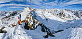 Panorama with woman on ski tour stands at Plereskopf, Ötztal Alps in the background, Plereskopf, Matscher Valley, Ötztal Alps, South Tyrol, Italy