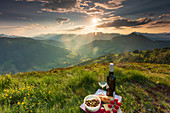 A picnic on the Schatzberg in Alpbach at sunset with a view of the surrounding mountain landscape in Tyrol