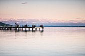 View of a jetty on Lake Starnberg at sunset, in the background the Alps, Starnberg, Bavaria, Europe