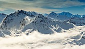 France, Savoie, Beaufortain, Hauteluce, mist in a snowy landscape at sunset