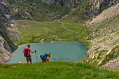 Wanderer steigen hinunter zum Lago Bianco, Trekking del Laghetti Alpini, Tessin, Schweiz