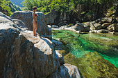Woman wearing bikini on rock by river